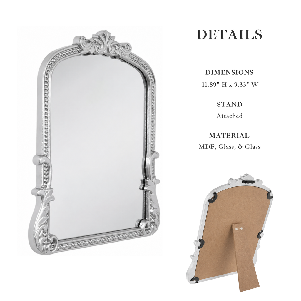 Ornate silver-framed wall mirror with decorative scrollwork corners and a matching stand, shown on a white background with text detailing dimensions, stand attachment, and MDF glass-and-glass material. A small rear view of the stand is shown on the right.